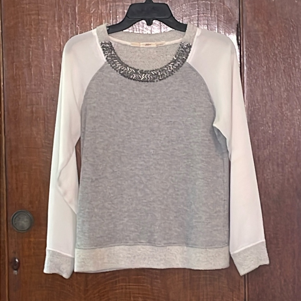 Sweatshirt type shirt with sheer sleeves. Neckline bedazzled.